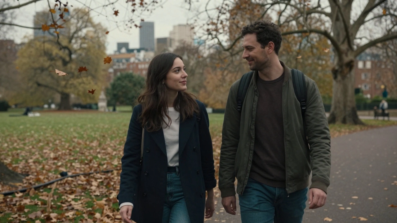 Two people walking together in Hyde Park during autumn, leaves falling, casual clothing, peaceful atmosphere.