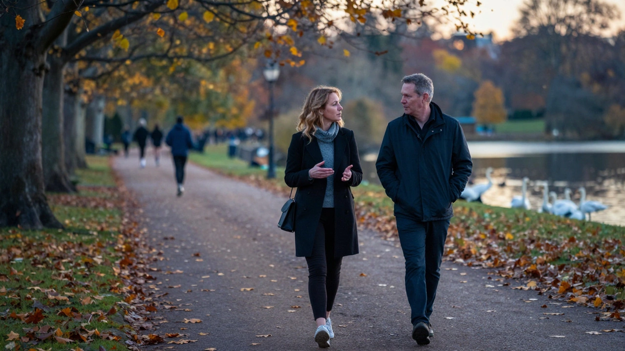 Two people walking peacefully through Hyde Park at sunset, lost in quiet conversation.